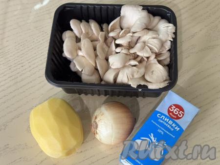 Подготовить продукты для приготовления крем-супа из вешенок со сливками. Картошку и лук почистить. Картофель выложить в миску, залить полностью водой, чтобы он не потемнел.