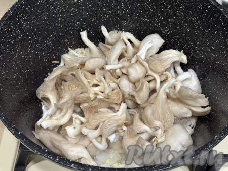 К обжаренному луку добавить вешенки, перемешать. Обжарить грибы с луком в течение 10 минут, время от времени помешивая. 