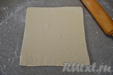 На присыпанной мукой поверхности разморозившееся слоёное бездрожжевое тесто раскатать скалкой в квадрат толщиной примерно 3 миллиметра. У меня получился квадрат со стороной 24 сантиметра.