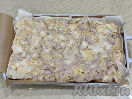 Выложить получившуюся массу в форму, застеленную лавашом, и слегка утрамбовать.