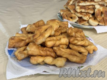 Пышный, аппетитный хворост переложить со сковороду на тарелку, застеленную бумажным полотенцем, чтобы удалить излишки масла. Аналогично постепенно пожарить весь хворост, не забывая подливать масло в сковороду по мере необходимости.