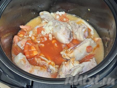 Затем влить в чашу мультиварки 500 миллилитров воды комнатной температуры, добавить томатную пасту, мелко нарезанные очищенные зубчики чеснока.