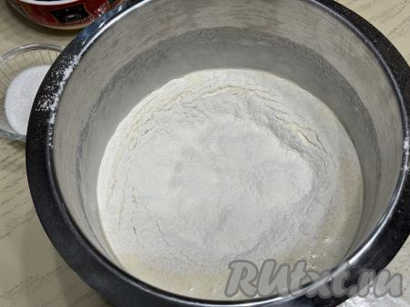 Муку просеять. Всыпать в чашу со взбитыми яйцами половину муки.