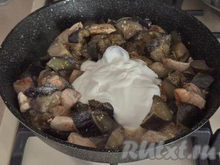 Сразу добавить в сковороду сметану и пропущенный через пресс чеснок, перемешать. Тушить курицу с баклажанами со сметаной под крышкой на медленном огне в течение 5 минут.