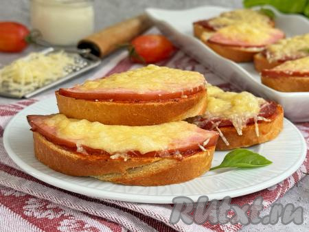 Переложить аппетитные, вкусные, сытные бутерброды с колбасой и сыром из чаши аэрогриля на тарелку и подать к столу в горячем виде. 