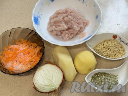 Подготовить продукты для приготовления супа с куриными фрикадельками в мультиварке. Куриное филе промыть водой, обсушить, пропустить через мясорубку в глубокую тарелку, посолить получившийся фарш, хорошо перемешать. Для этого блюда можно взять и покупной куриный фарш, его тоже нужно будет посолить. Картошку, лук и морковь очистить. Картофель залить полностью водой и оставить на время, пока будем заниматься обжариванием других овощей. 