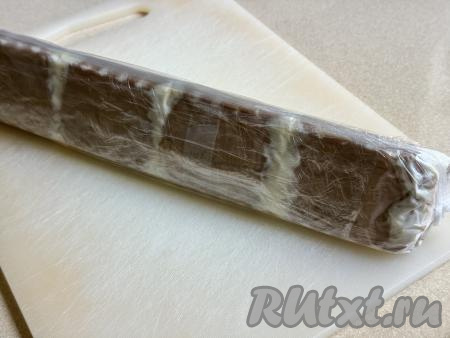 Полностью завернуть домик из печенья и творога в целлофан (можно взять ещё 1-2 пакета, если домик не помещается полностью в целлофан). Убрать десерт в холодильник на ночь для пропитки.