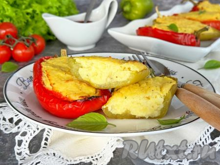 Готовые болгарские перцы, фаршированные картофельным пюре, достать из духовки,  переложить на тарелку и подать в горячем виде к столу.