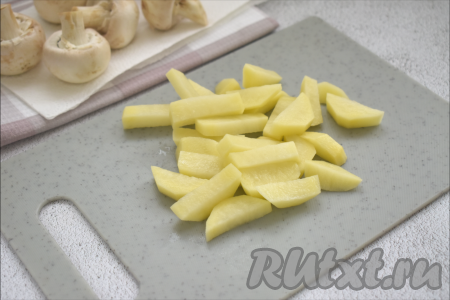 Наливаем в кастрюлю 1,5 литра воды, по вкусу солим, ставим на огонь, доводим до кипения. Пока закипает вода, очищаем морковку, лук и картофель. Нарезаем картошку на средние брусочки (или кубики), выкладываем в закипевшую воду. Ещё раз даём воде закипеть, уменьшаем огонь, варим картофель 15 минут.