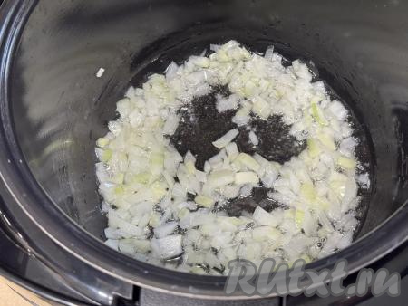 Растительное масло влить в чашу мультиварки, выставить режим "Жарка" на 15 минут. Лук очистить, мелко нарезать, выложить в чашу мультиварки. Жарить лук в течение 5-6 минут (до прозрачности), не закрывая чашу мультиварки крышкой и периодически перемешивая. 