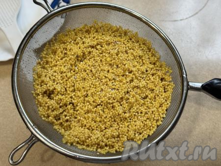 Пшено выложить в сито, тщательно промыть горячей водой, лишней воде дать стечь. 
