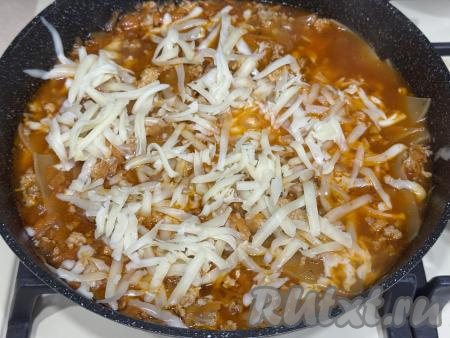 Сыр натереть на крупной тёрке, выложить в сковороду поверх лазаньи.