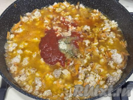 Затем в сковороду с фаршем и овощами нужно влить примерно 500 миллилитров воды, добавить томатную пасту, всыпать соль и специи по вкусу. 