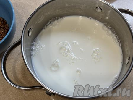 В кастрюлю с толстым дном влить молоко, добавить соль и 2 столовых ложки сахара, перемешать, поставить на достаточно сильный огонь. 