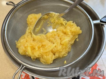 Взять миску, на неё поставить сито. Выложить в сито мягкую яблочную массу. Перетереть яблочную массу с помощью столовой ложки через сито в миску. В процессе перетирания в миске окажется однородное яблочное пюре. В сите останется практически сухие остатки яблочной массы, которые нам не понадобятся.  