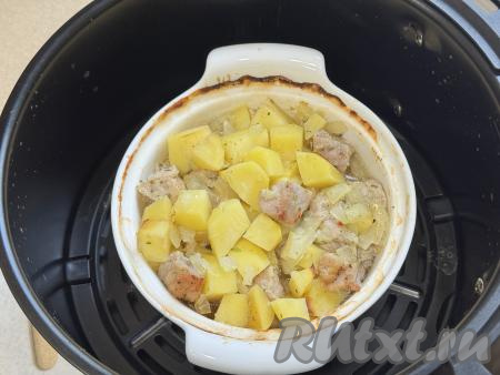 По прошествии 30 минут открыть горшочек. Проверить картофель на готовность, он должен стать достаточно мягким, легко прокалываться ножом. Если картошка твердовата (многое зависит от сорта картофеля), тогда закрыть горшочек крышкой и готовить при температуре 200 градусов ещё 5-10 минут. Затем открыть горшочек и готовить мясо с картошкой в аэрогриле ещё 5 минут.