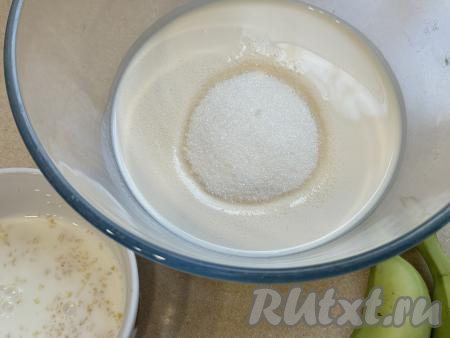 В отдельную миску влить ряженку, всыпать сахар, перемешать и оставить минут на 15 (до полного растворения сахара).