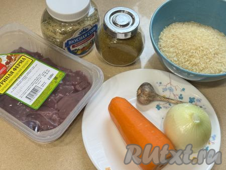 Подготовить продукты для приготовления куриной печени с рисом в мультиварке. Лук, чеснок и морковь почистить. Рис выложить в сито, хорошо промыть его водой, оставить в сите, чтобы стекла лишняя жидкость.