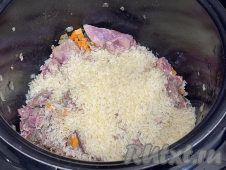 После окончания режима "Жарка" всыпать в чашу мультиварки подготовленный рис.