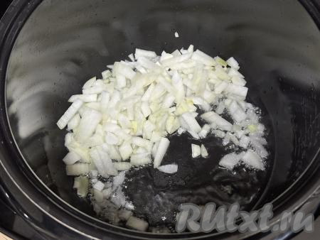 В чашу мультиварки влить растительное масло, выставить на 15 минут режим "Жарка". Выложить в чашу с маслом мелко нарезанный лук, обжарить его до прозрачности (в течение 6-7 минут), время от времени помешивая и не закрывая крышку мультиварки. 