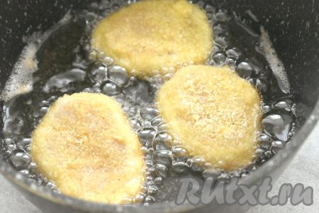 В сковороду вливаем достаточное количество растительного масла, хорошо разогреваем его. Наггетсы из куриного фарша выкладываем на сковороду в горячее масло, жарим на среднем огне до золотистого оттенка с двух сторон (примерно по 2,5-3 минуты с каждой стороны).