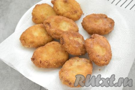 Жареные куриные наггетсы со сковороды перекладываем на бумажные полотенца, чтобы удалить излишки масла. Постепенно жарим все наггетсы. При необходимости в процессе жарки подливаем в сковороду масло.
