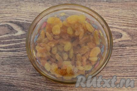 Первым дело займёмся изюмом, его нужно выложить в небольшую миску, залить полностью кипятком и оставить на 5 минут. За это время изюм распарится и станет более мягким.