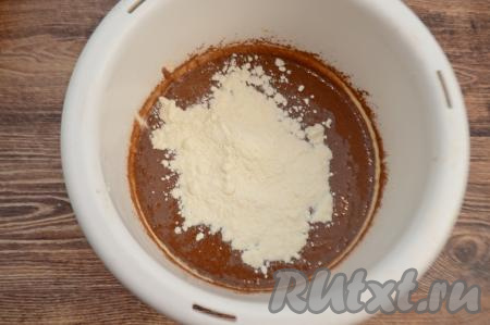 В получившуюся шоколадную массу всыпать весь разрыхлитель и 50 грамм муки, перемешать движениями лопатки снизу вверх, полностью вмешивая муку. 