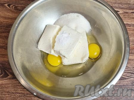 В достаточно объёмную миску выложить творог, сразу добавить яйца, сахар, соду, растереть лопаткой (или вилкой) до получения однородной творожной массы.