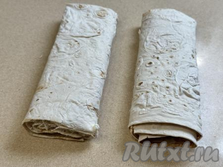 Сформированный рулет с творогом разрезать на 2 части. Рулет из лаваша целиком не поместится в чашу аэрогриля, поэтому его и нужно разрезать на 2 части.