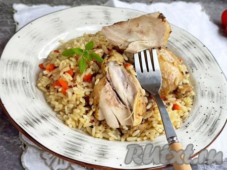 Перемешать рассыпчатый рис с нежными, сочными куриными бёдрами, разложить из чаши мультиварки по тарелкам и в горячем виде подать к столу.