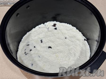 Дно чаши мультиварки застелить пергаментом. Растительным маслом смазать пергамент и бока мультиварки. В подготовленную чашу выложить творожно-манное тесто, разровнять. 