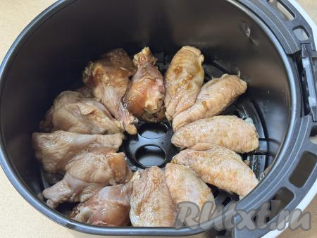 Чашу аэрогриля, по желанию, застелить фольгой, я не застилала. Куриные крылышки, промариновавшиеся в соево-медовом соусе, выложить в чашу аэрогриля в один слой. 