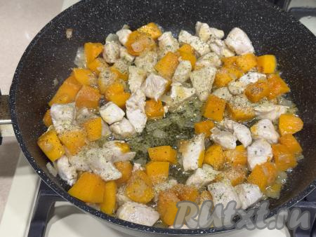 Томить мясо курицы с тыквой под крышкой минут 15 (до мягкости тыквы), время от времени помешивая. Если жидкости в сковороде будет мало, для того чтобы блюдо не пригорело, можно в процессе томления добавить в сковороду 2-3 столовых ложки воды. В конце тушения посолить блюдо, приправить специями по вкусу. 