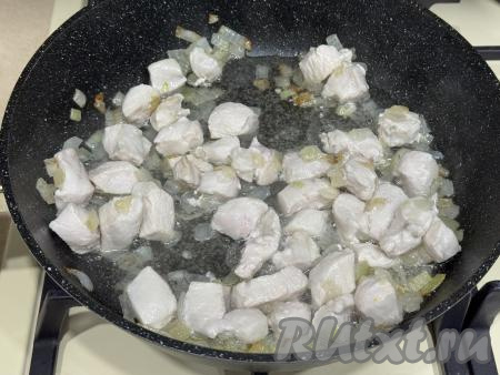 Обжарить кусочки мяса курицы с луком в течение 10 минут, периодически перемешивая. 