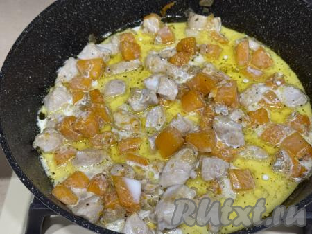 Влить в сковороду сливки, перемешать. Дать сливками закипеть, сразу уменьшить огонь. Томить мясо курицы с тыквой в сливочном соусе 5-7 минут, иногда перемешивая. Сливки лучше всего взять жирностью 10-20% (я купила жирностью 10%).