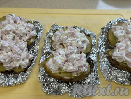 Затем на каждую половинку картошки сверху разложить подготовленную начинку.