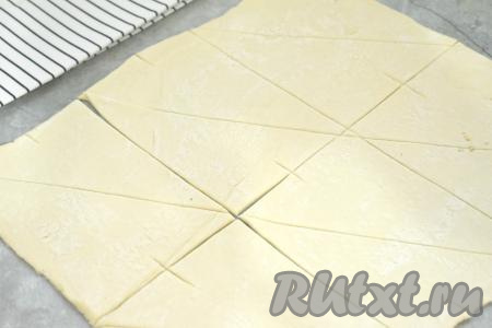 Каждую из 6 прямоугольных частей теста разрезаем по диагонали. В итоге получаются 12 треугольников из теста. У основания каждого треугольника делаем небольшой надрез, как на фото.