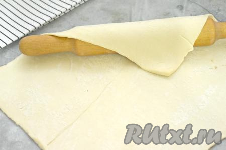 Размороженный пласт слоёного теста выкладываем на стол, припорошенный мукой, и раскатываем в квадрат со сторонами около 30 сантиметров.