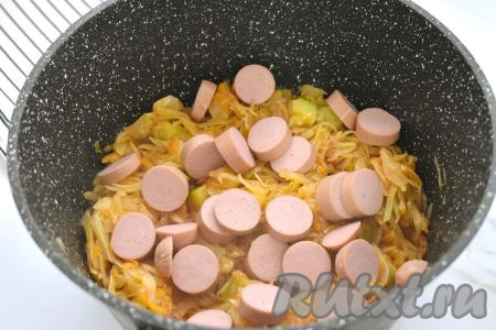 Затем к капусте, протушившейся с кабачками, выкладываем сосиски, очищенные от слюды и нарезанные на кружочки, перемешиваем. Пробуем блюдо на вкус, если нужно, тогда досаливаем.