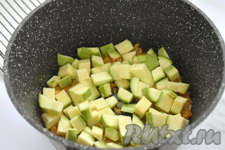 К обжаренным овощам выкладываем кабачки, перемешиваем, обжариваем 5 минут время от времени перемешивая.