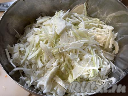 Нарезать 1 килограмм капусты на тонкие полоски, выложить в глубокую миску. 