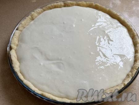 Вылить сметанную заливку в форму поверх клюквы.