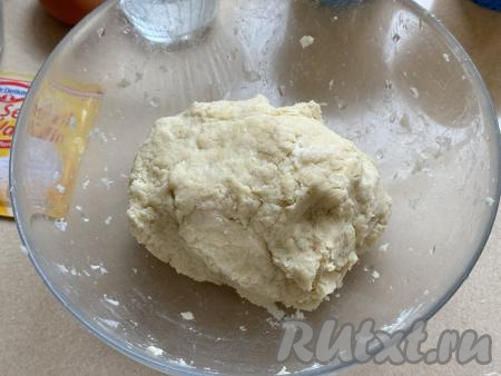 Замесить руками мягкое и пластичное песочное тесто, которое практически не липнет к рукам. Если тесто будет рассыпаться и не собирается в ком, тогда добавьте 0,5-1 столовую ложку холодной воды и вмешайте её, собирая тесто в ком. Песочное тесто не нужно долго вымешивать, достаточно, чтобы оно собралось в ком.