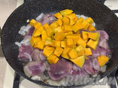Обжарить куриную печень в течение 2 минут, иногда помешивая. 200 грамм тыквы, заранее очищенной от кожуры, волокон и семечек, нарезать на кубики с размером стороны 1,5 сантиметра. После того как печёнка обжарится 2 минуты, добавить в сковороды кусочки тыквы, перемешать. 