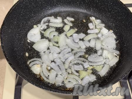 Лук и чеснок очистить. В сковороду влить растительное масло, разогреть, выложить лук, нарезанный на четверть кольца, обжарить до прозрачности (минуты 3-4), время от времени помешивая, на среднем огне. 