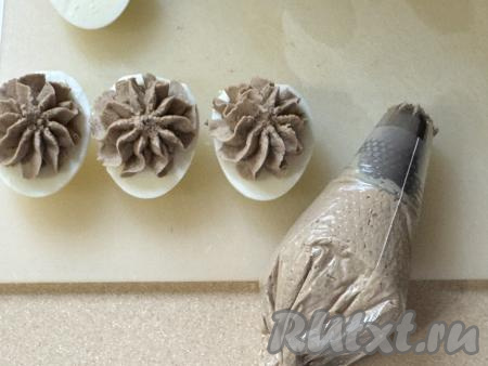 Выложить печёночную массу в кулинарный мешок и отсадить в лодочки из белка. Можно просто выложить массу ложкой. 