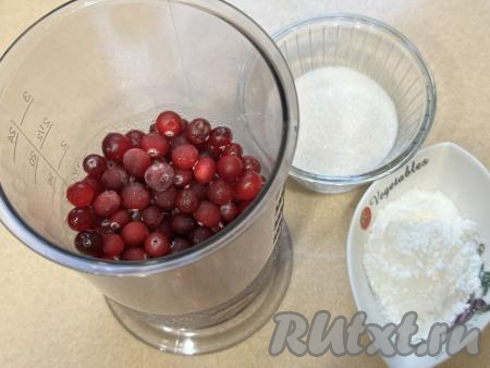 Пока основа выпекается, займёмся ягодной начинкой для пирога. Для этого в достаточно глубокой ёмкости нужно соединить клюкву, сахар и крахмал, пробить погружным блендером до однородности.