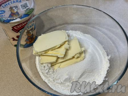 Прежде всего замесим песочное тесто, для этого в миске нужно соединить муку, соль и сахар. Достать из холодильника сливочное масло, нарезать его на небольшие кусочки, добавить в миску с мукой, сахаром и солью.