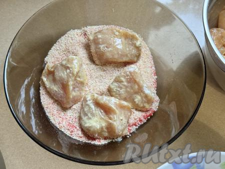 Затем обвалять кусочки грудки в панировочных сухарях со всех сторон. Обваливать в муке, яйцах и сухарях нужно столько кусочков филе куриной грудки, сколько у вас одновременно поместятся в чаше аэрогриля.